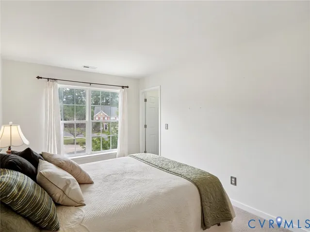 a bedroom with a bed and a large window