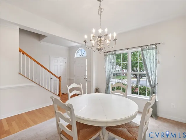 a view of a dining room with furniture a chandelier and wooden floor