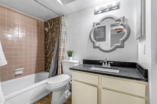 a bathroom with a toilet sink vanity tub and shower