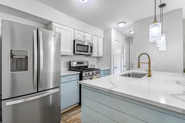 a kitchen with stainless steel appliances a refrigerator stove and sink