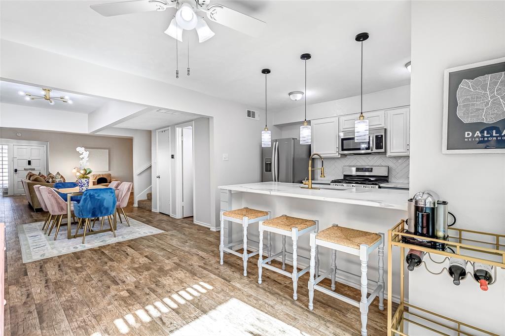 3740 Vitruvian Way, Unit D Addison, TX 75001 - Photo 8 of 22 a kitchen with kitchen island granite countertop a table chairs sink and cabinets
