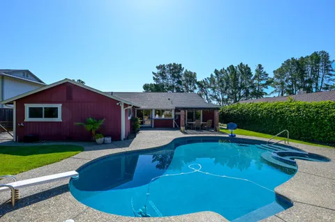 a view of a house with swimming pool and yard
