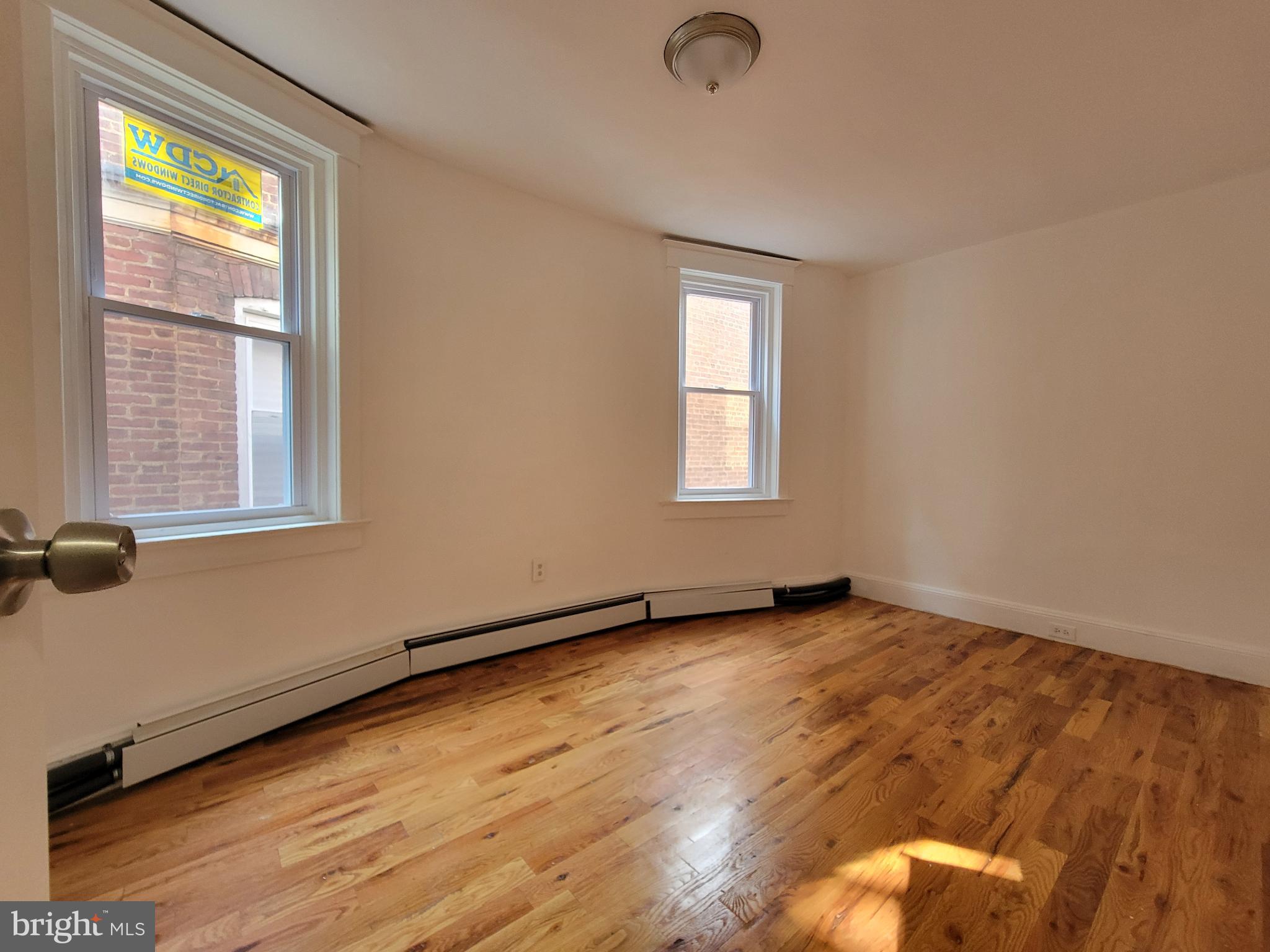 238 Rosemont Avenue Trenton, NJ 08618 - Photo 4 of 9 an empty room with wooden floor and windows