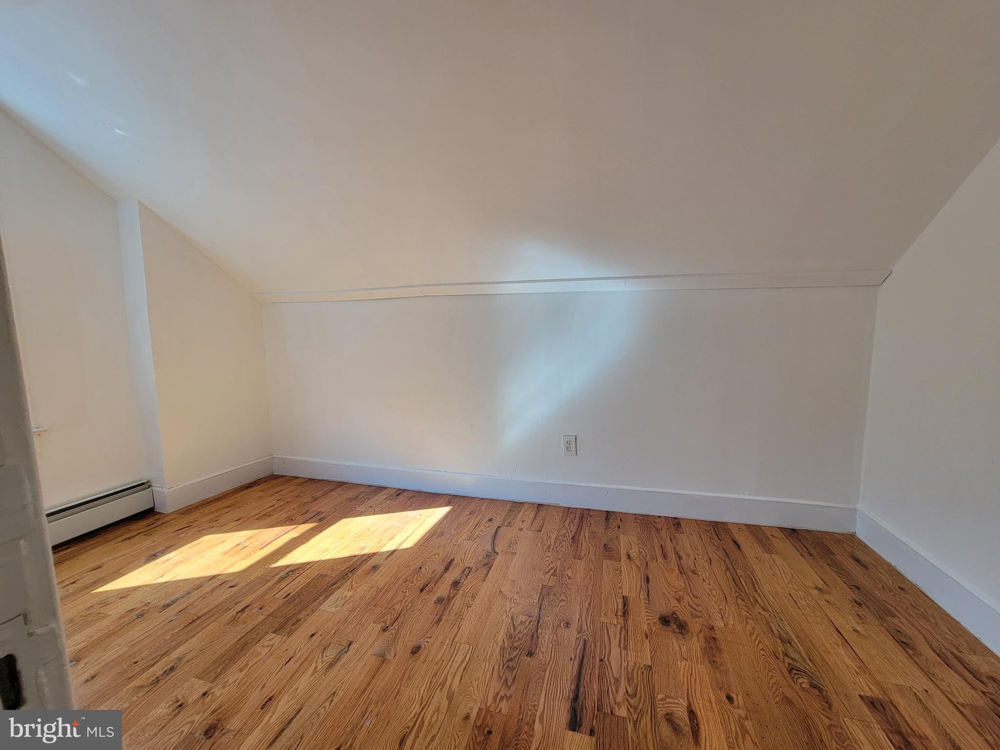 238 Rosemont Avenue Trenton, NJ 08618 - Photo 5 of 9 a view of an empty room with wooden floor and a window