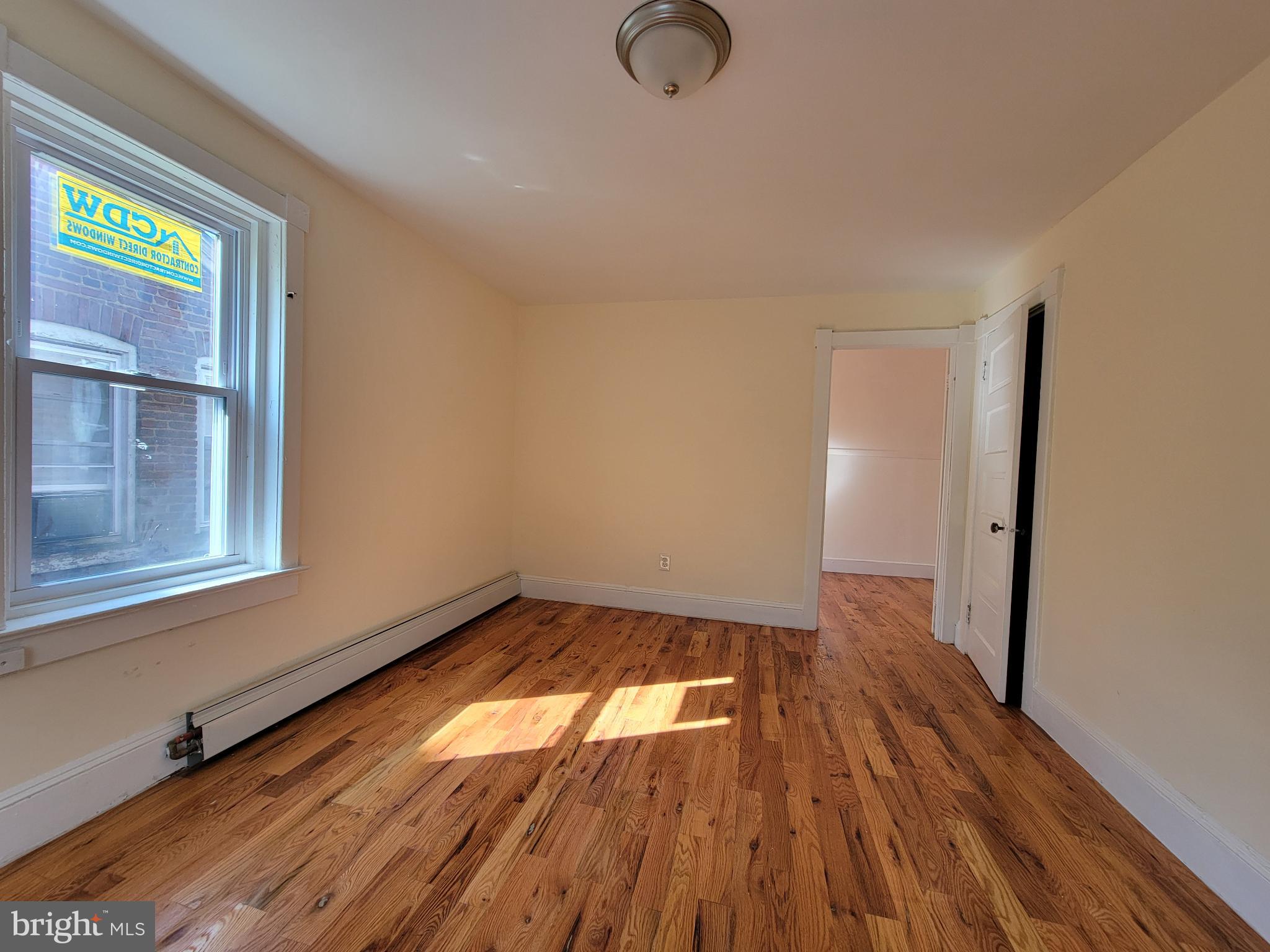 238 Rosemont Avenue Trenton, NJ 08618 - Photo 8 of 9 an empty room with wooden floor and windows