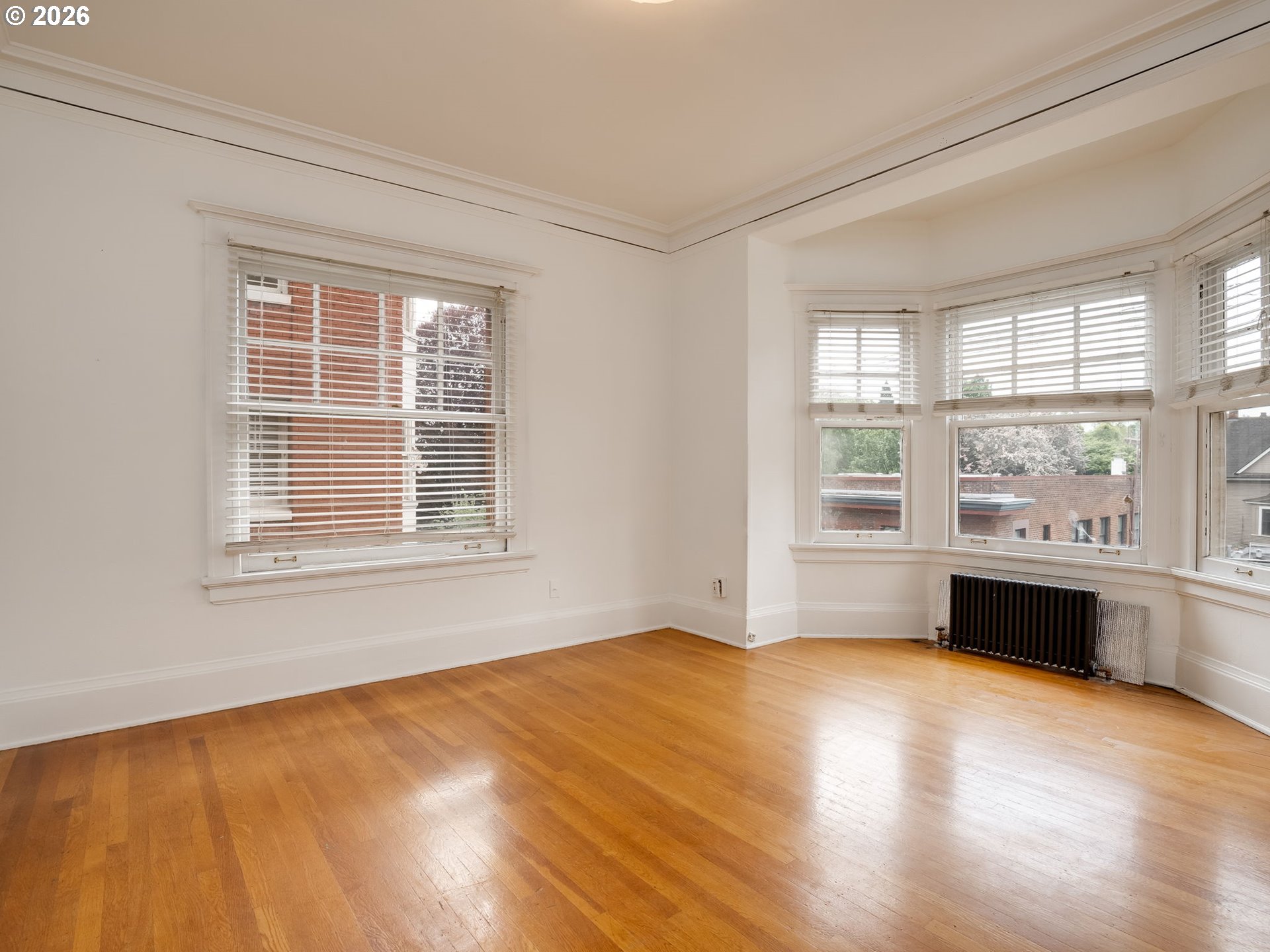 2083 Northwest Johnson Street, Unit 41 Portland, OR 97209 - Photo 21 of 25 a view of an empty room with a window and wooden floor