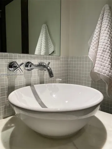 a bathroom with a white sink a toilet and mirror