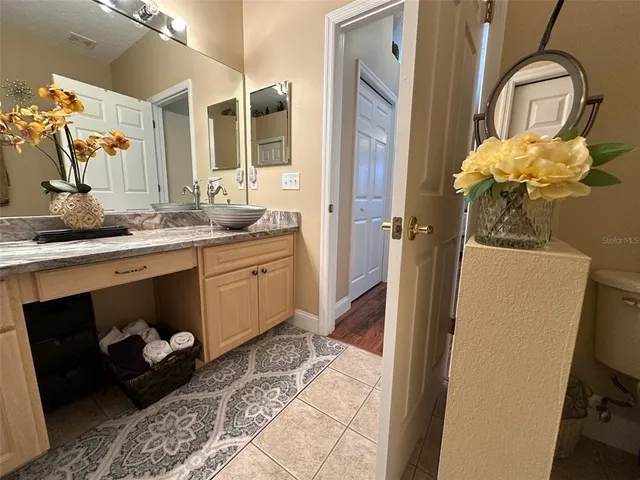 a bathroom with a granite countertop sink a toilet and a mirror