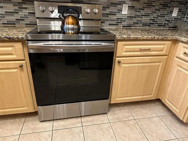 a kitchen with stainless steel appliances granite countertop a sink stove and microwave