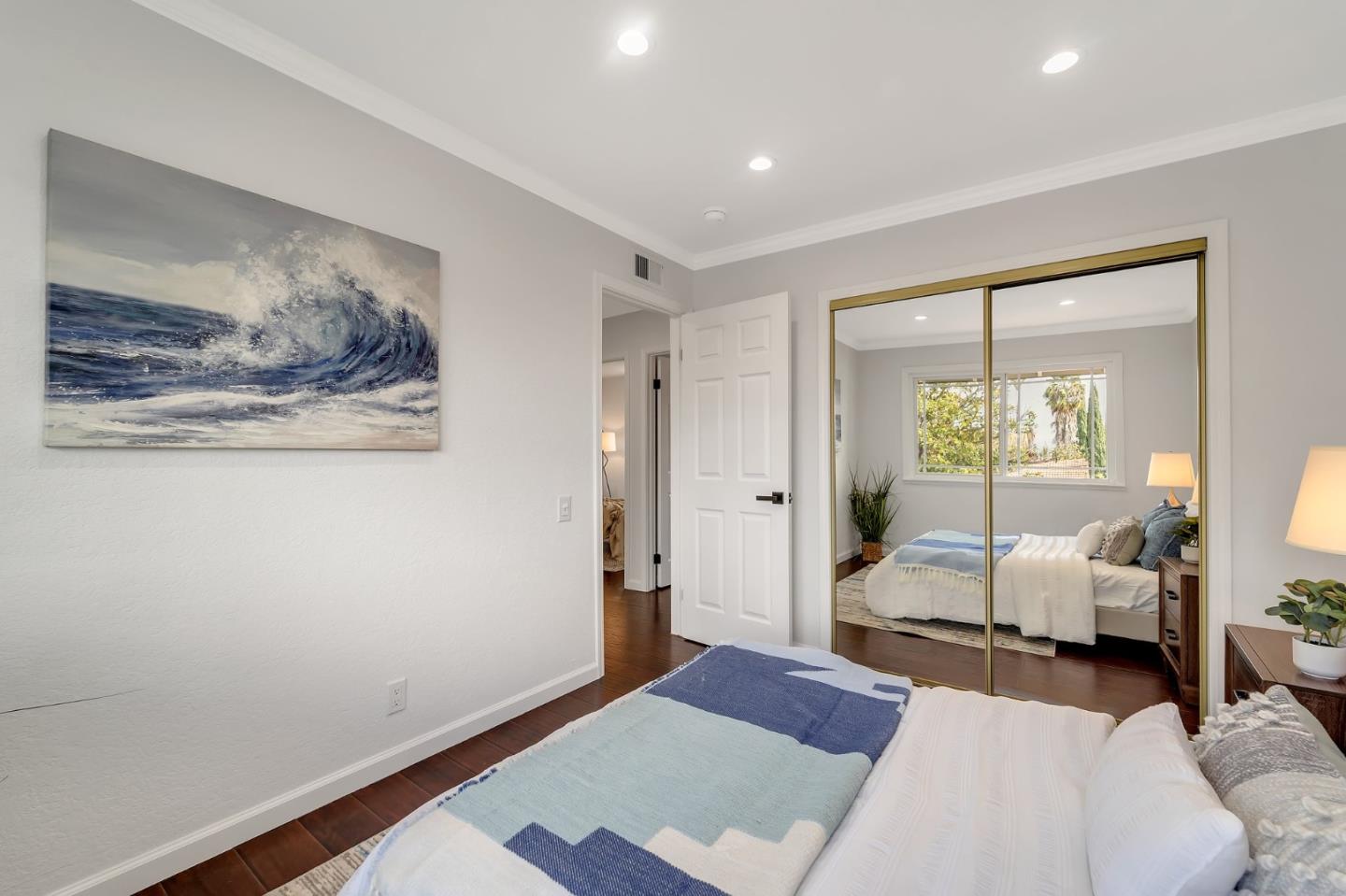 4824 Poston Drive San Jose, CA 95136 - Photo 19 of 33 a bedroom with a bed and large mirror with wooden floor