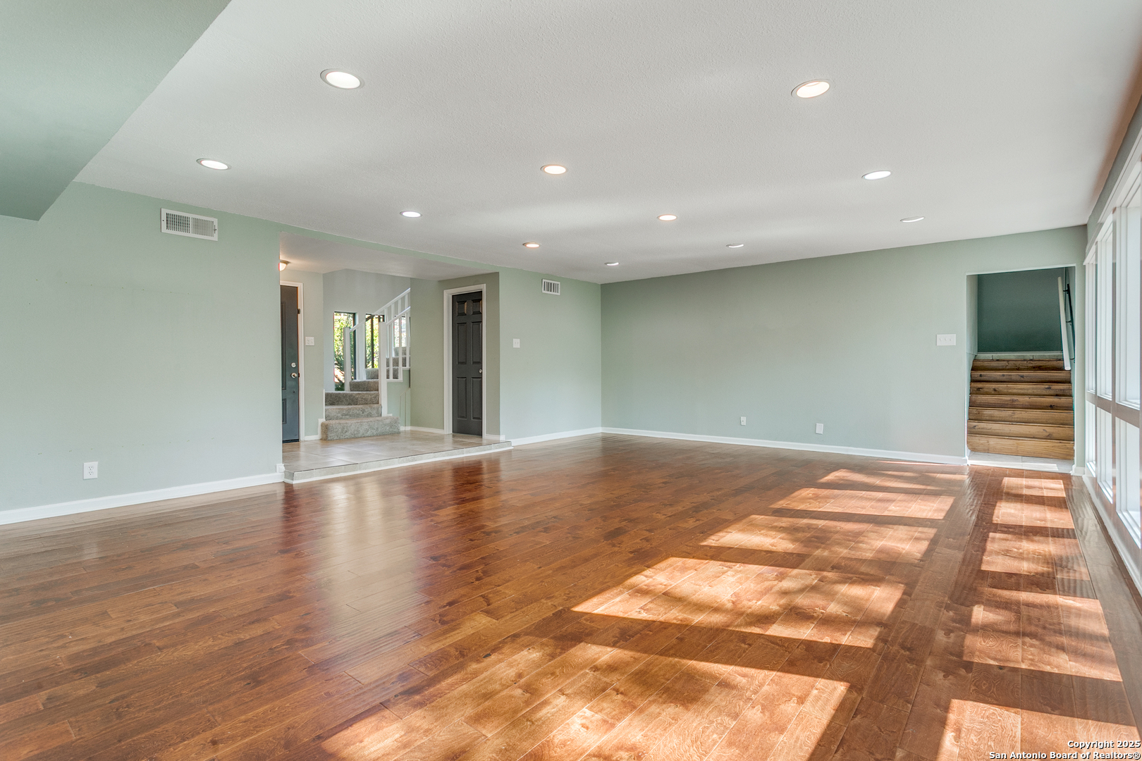 11410 Whisper Moss Street San Antonio, TX 78230 - Photo 13 of 44 a view of an empty room with wooden floor and kitchen