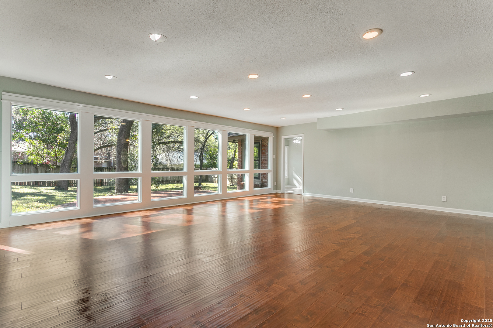 11410 Whisper Moss Street San Antonio, TX 78230 - Photo 14 of 44 a view of an empty room with wooden floor and a window
