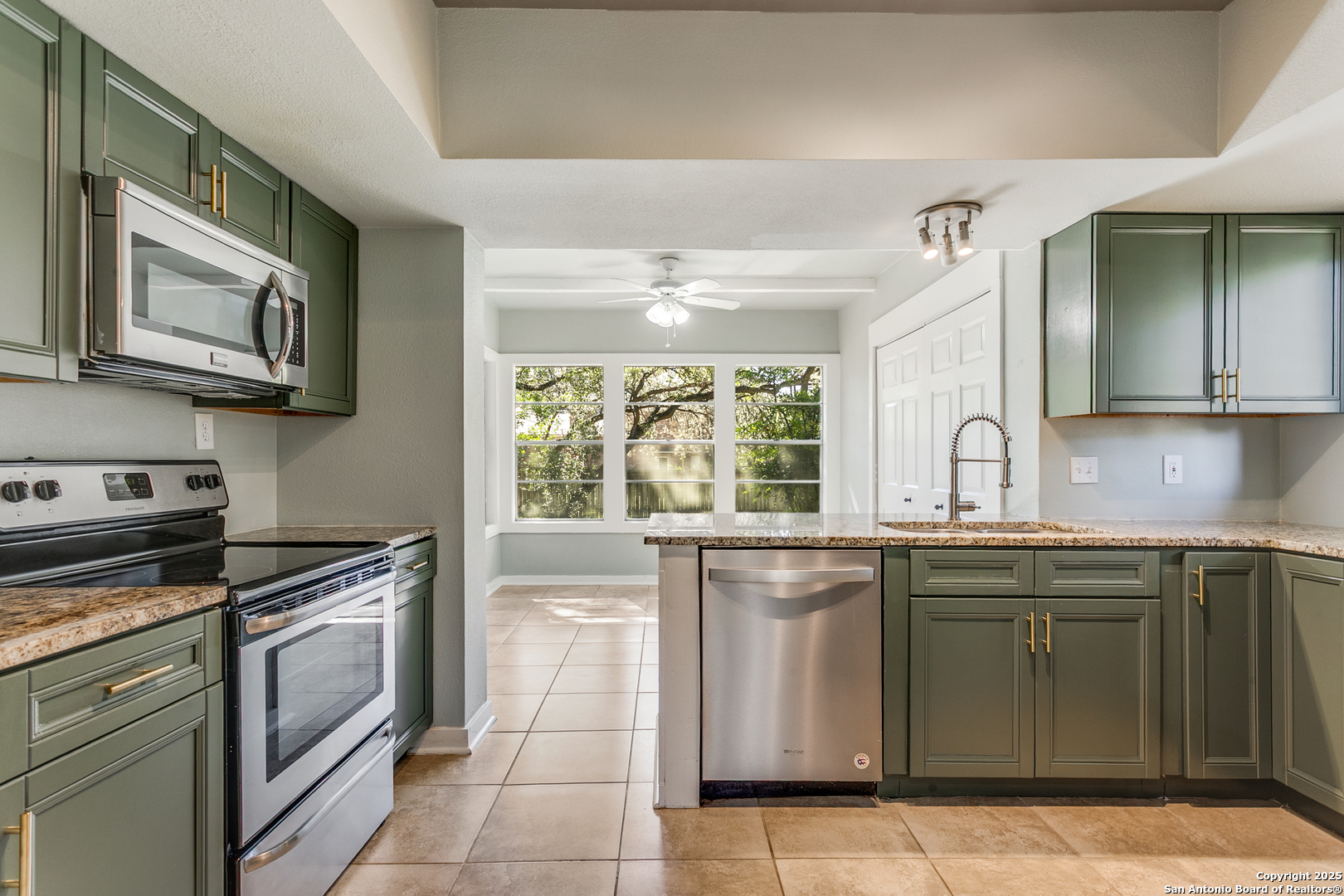 11410 Whisper Moss Street San Antonio, TX 78230 - Photo 19 of 44 a kitchen with stainless steel appliances granite countertop a stove a sink and a microwave