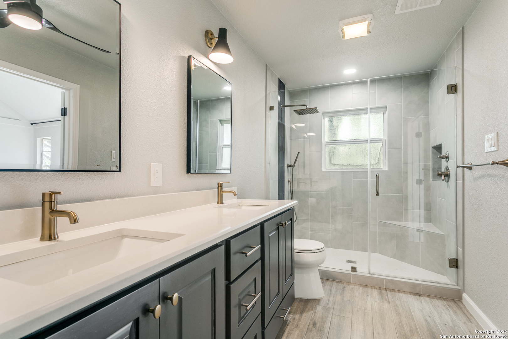 11410 Whisper Moss Street San Antonio, TX 78230 - Photo 26 of 44 a bathroom with a sink a toilet a shower and a mirror