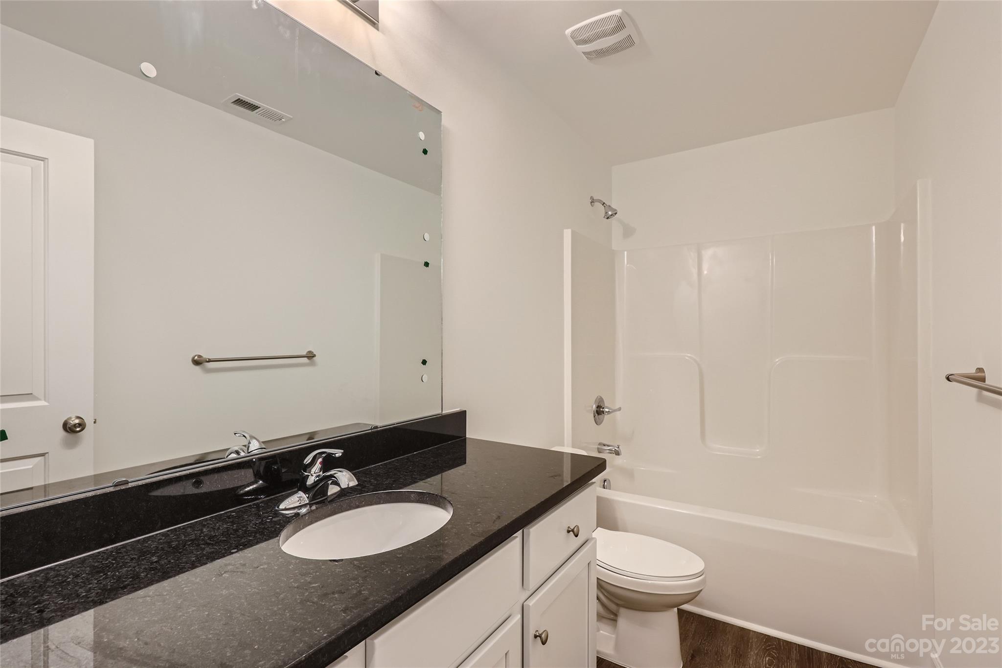 817 North Ransom Street Gastonia, NC 28052 - Photo 7 of 11 a bathroom with a granite countertop sink toilet a mirror and shower