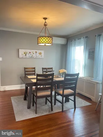 a view of a dining room with furniture a chandelier and wooden floor