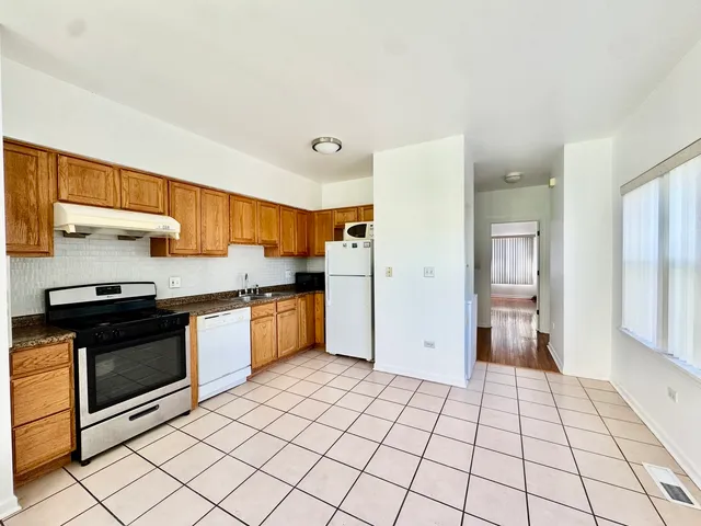 a kitchen with stainless steel appliances granite countertop a refrigerator and a sink