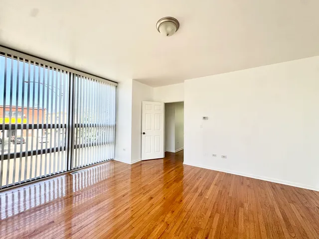 a view of an empty room with wooden floor