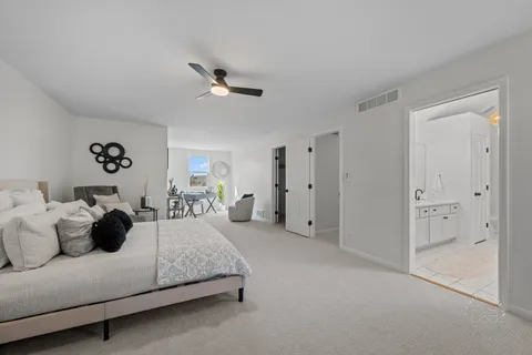 a spacious bedroom with a bed and ceiling fan