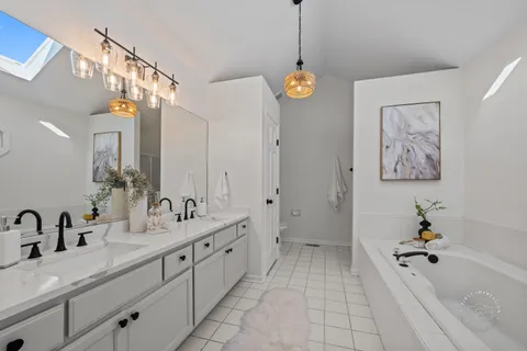 a spacious bathroom with a tub sink and mirror