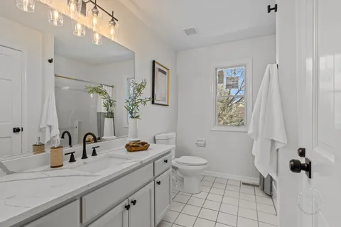 a bathroom with a granite countertop sink mirror vanity and toilet