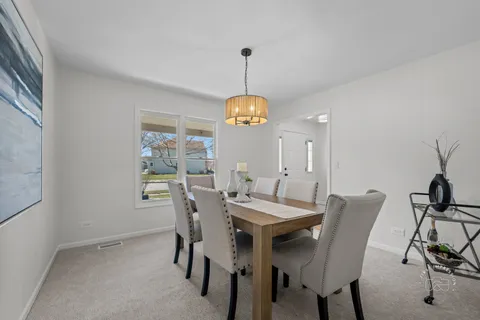a dining room with furniture window and wooden floor