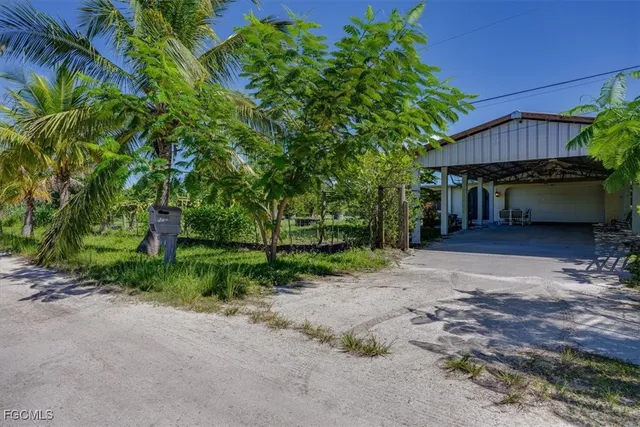 a view of a house with a yard and tree