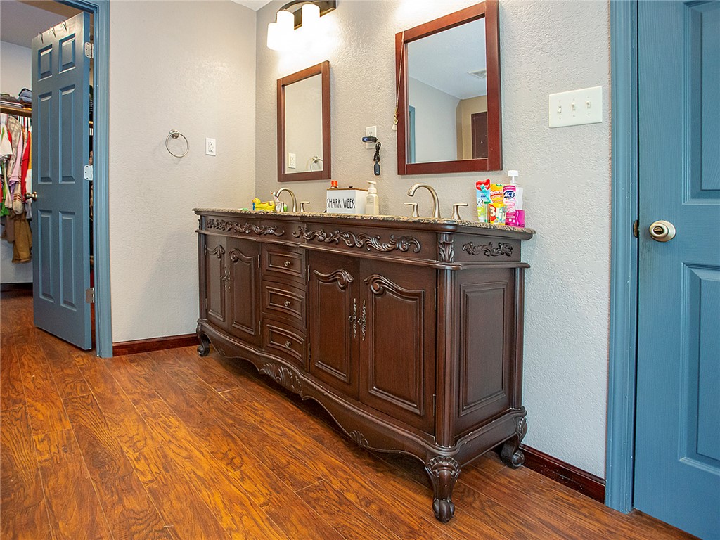 3726 St Joe Road Atkins, AR 72823 - Photo 14 of 41 Dual sink vanity with intricate carved details, a granite countertop, and wood-finish flooring