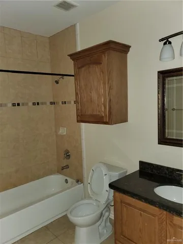 a bathroom with a granite countertop sink toilet and bathtub