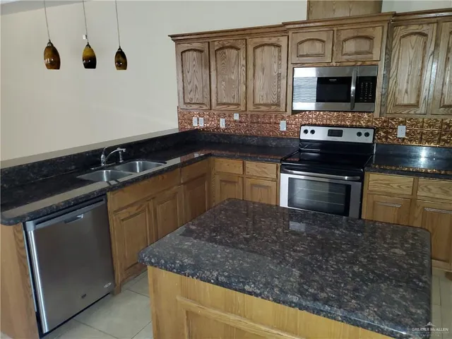 a kitchen with granite countertop a sink and a stove