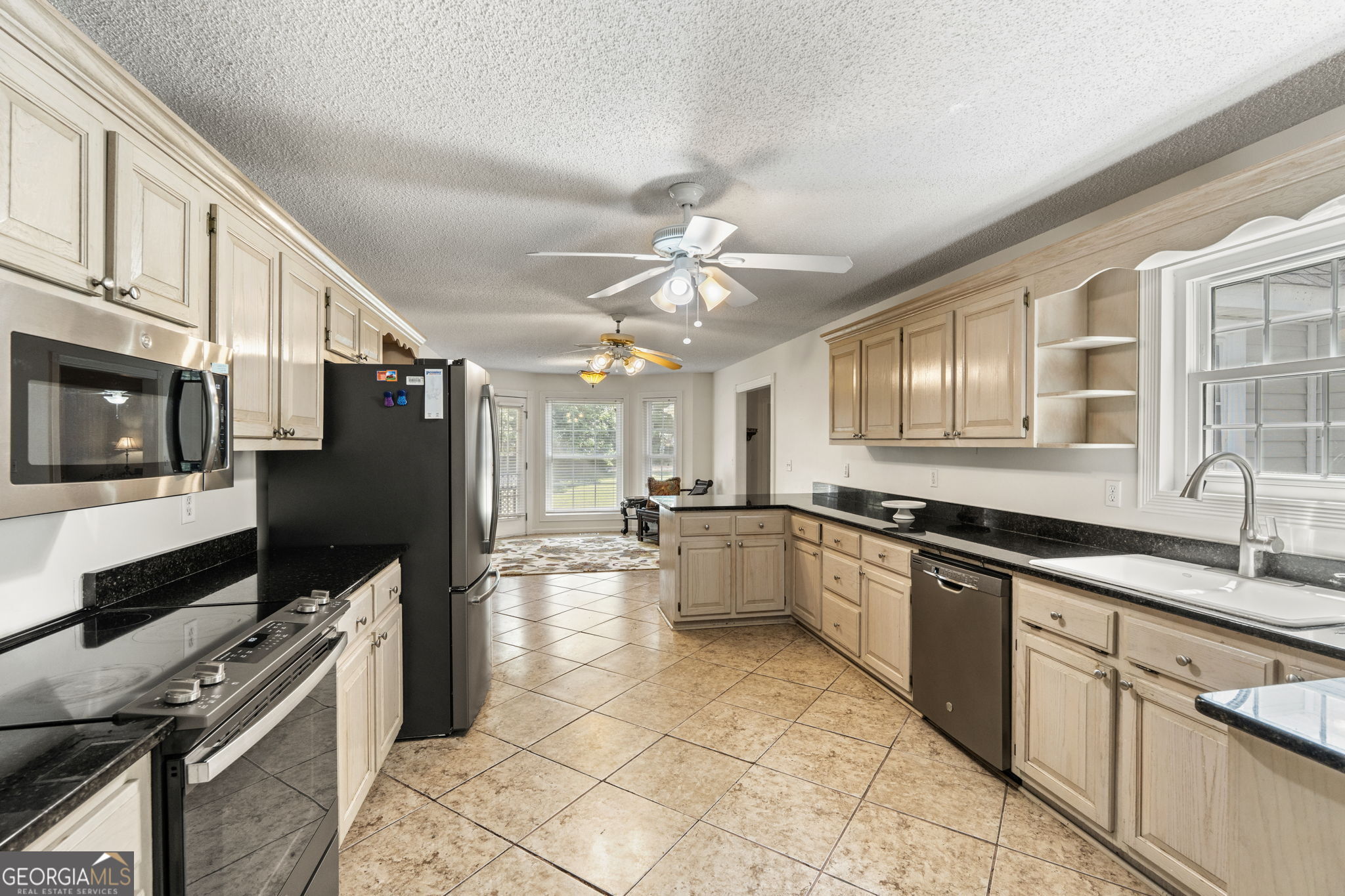 119 Moll Drive Cochran, GA 31014 - Photo 18 of 66 a large kitchen with stainless steel appliances granite countertop a large stove a sink dishwasher and white cabinets with wooden floor