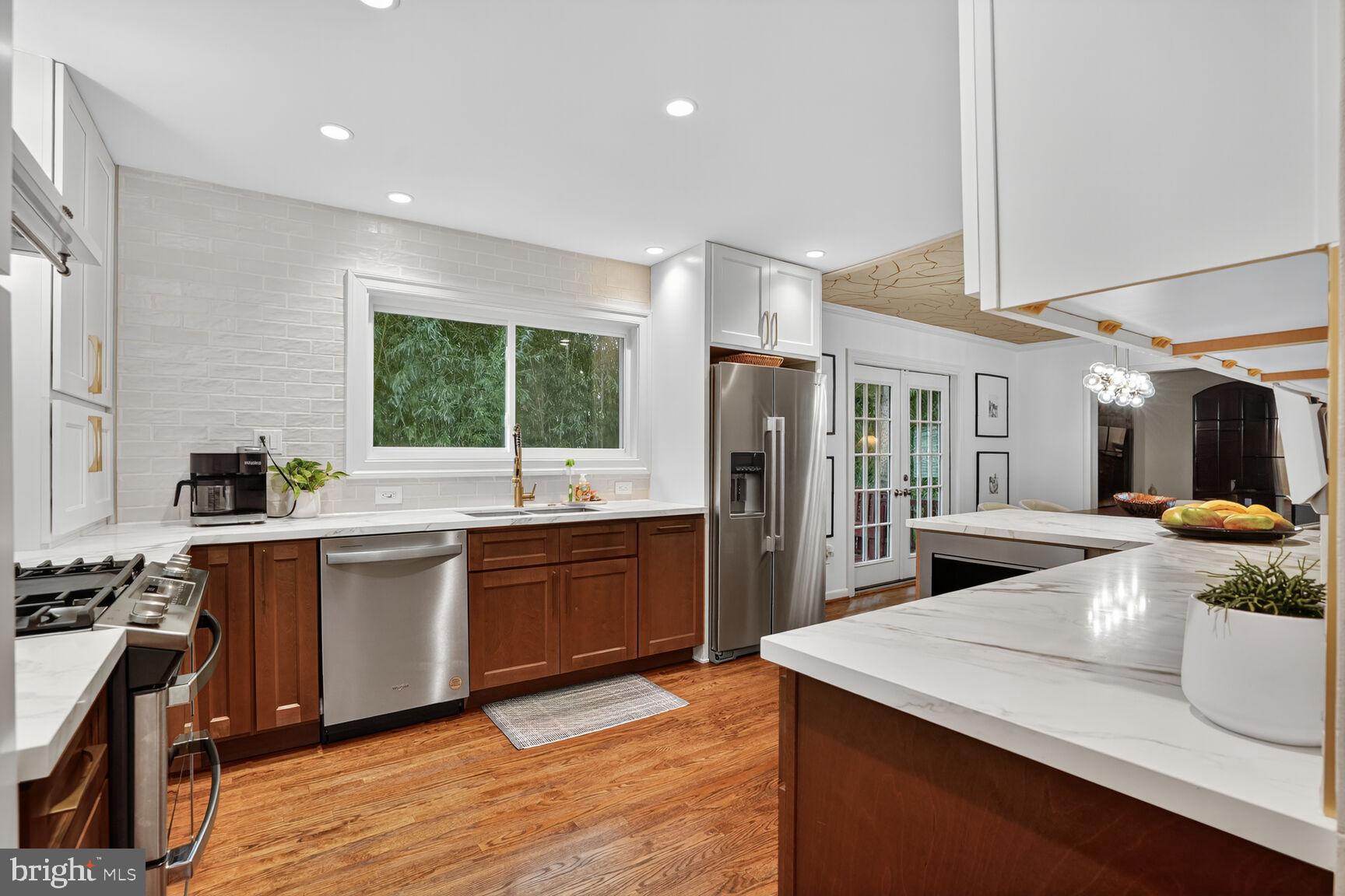 4004 David Lane Alexandria, VA 22311 - Photo 6 of 25 a large kitchen with kitchen island a large counter top space a sink stainless steel appliances and cabinets