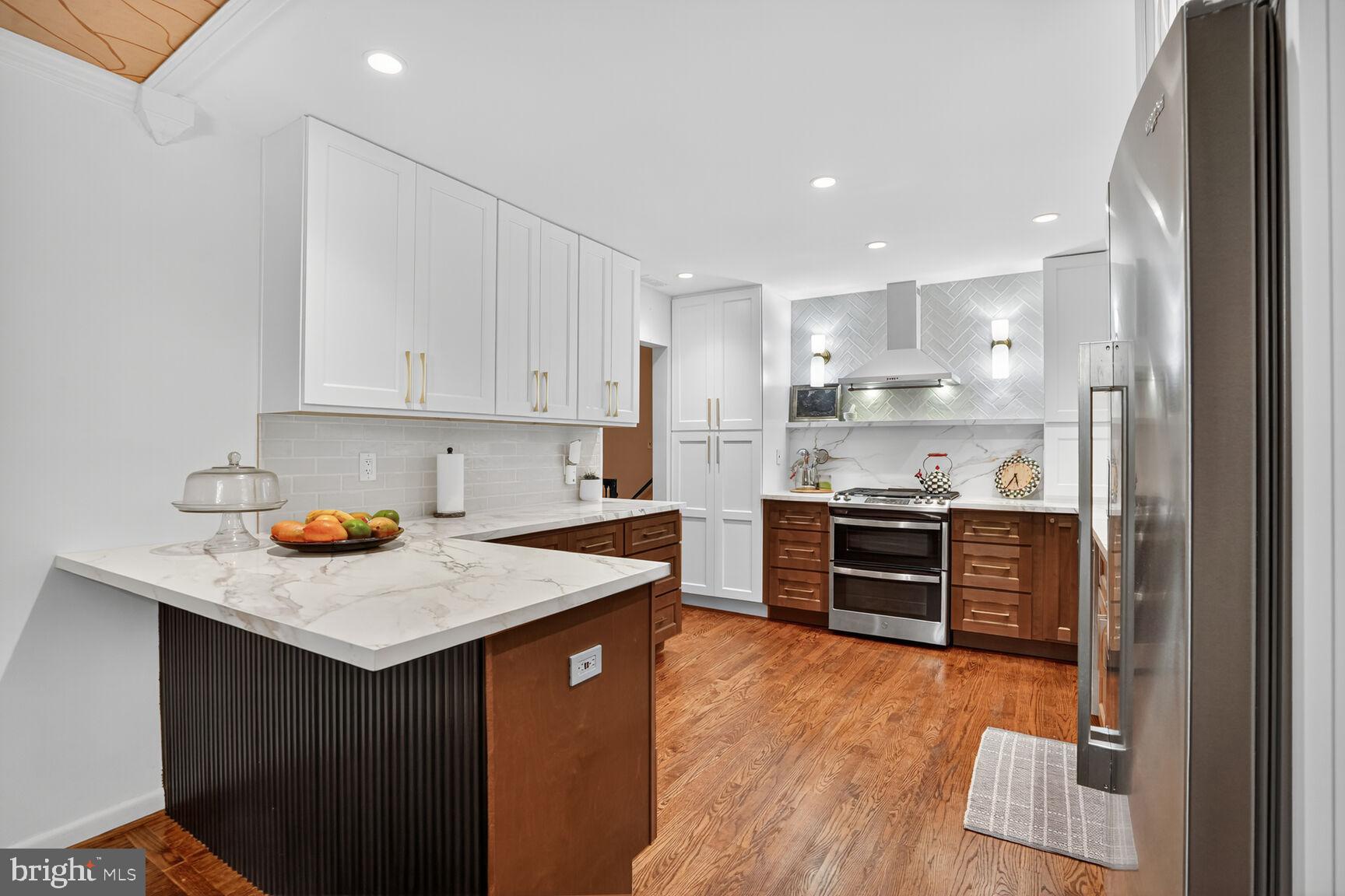 4004 David Lane Alexandria, VA 22311 - Photo 8 of 25 a kitchen with stainless steel appliances granite countertop a stove top oven a refrigerator a sink and dishwasher with white cabinets