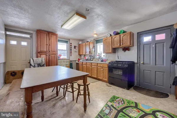 a kitchen with a refrigerator a stove and white cabinets with wooden floor