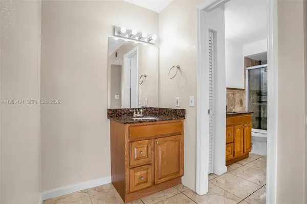 an empty room with kitchen and chandelier fan
