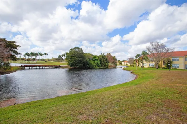a front view of a house with garden and trees