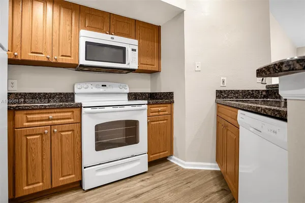 a kitchen with stainless steel appliances granite countertop a stove microwave and sink