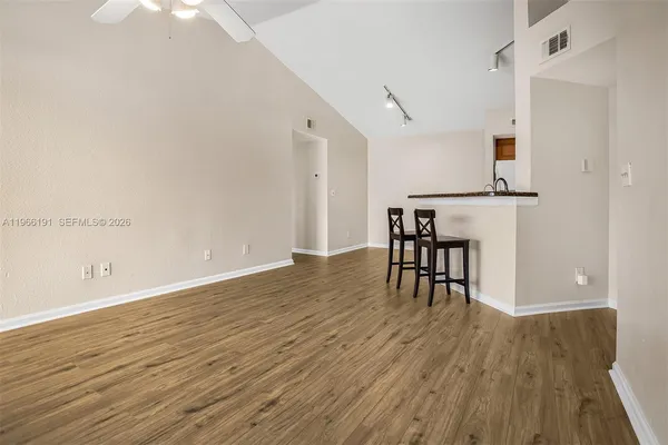 a view of a room with wooden floor table and chairs