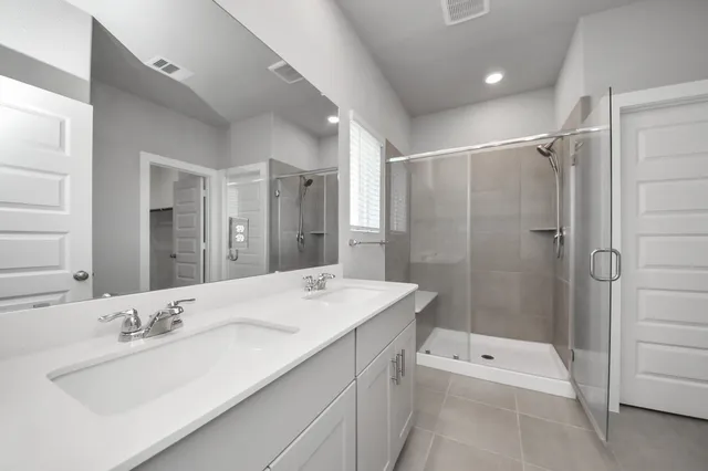 a bathroom with a double vanity sink a mirror and a bathtub