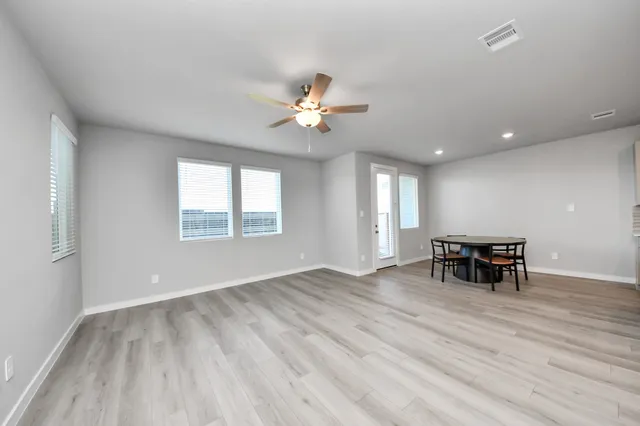 an empty room with furniture and chandelier fan