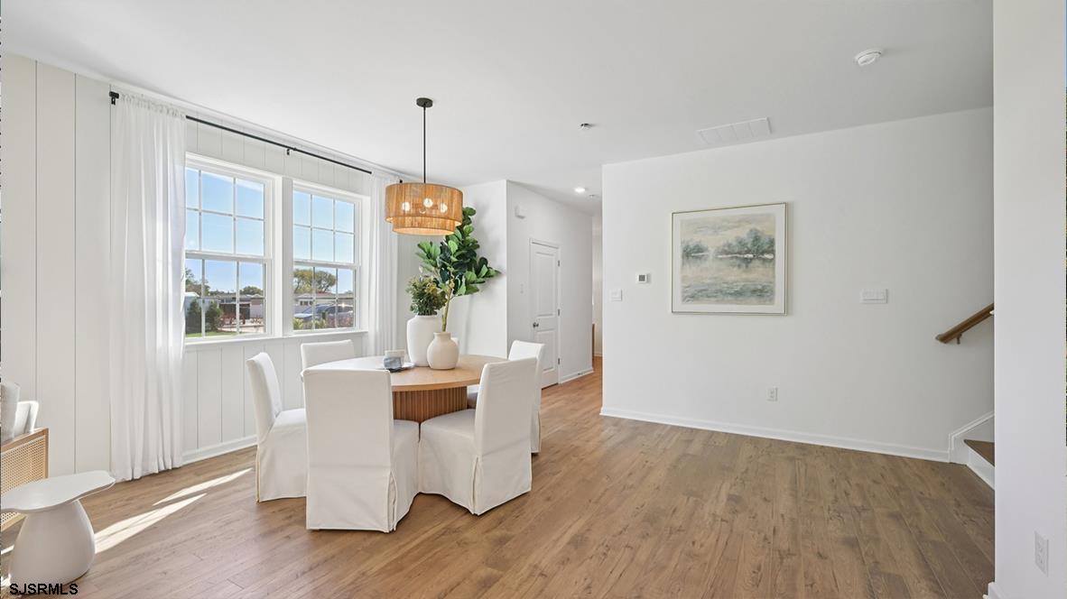 507 Scotty Boulevard, Unit 1301 Rio Grande, NJ 08242 - Photo 13 of 43 a dining room with furniture a chandelier and wooden floor