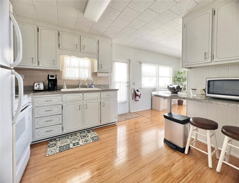 1100 South Belcher Road, Unit 270 Largo, FL 33771 - Photo 12 of 32 a kitchen with stainless steel appliances kitchen island granite countertop a sink cabinets and wooden floor