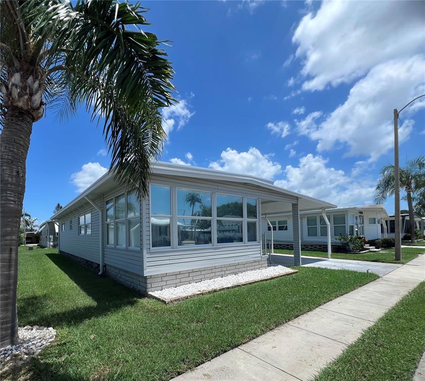 1100 South Belcher Road, Unit 270 Largo, FL 33771 - Photo 2 of 32 a front view of a house with a garden and trees