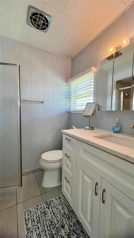 1100 South Belcher Road, Unit 270 Largo, FL 33771 - Photo 27 of 32 a bathroom with a granite countertop toilet a sink a mirror and shower