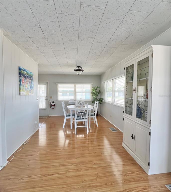 1100 South Belcher Road, Unit 270 Largo, FL 33771 - Photo 8 of 32 a dining room with furniture a chandelier and wooden floor