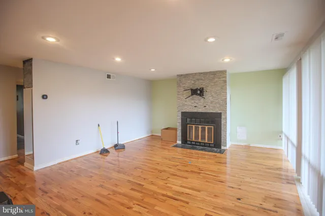 a big room with wooden floor and a ceiling fan