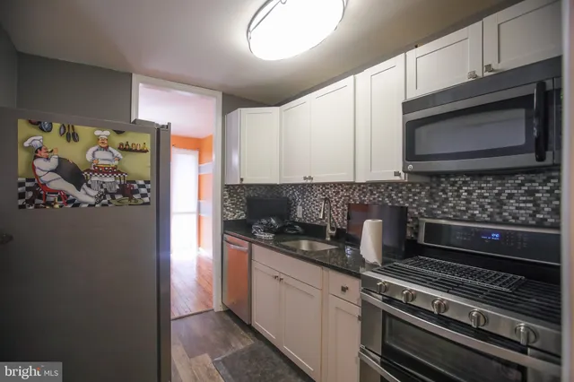 a kitchen with stainless steel appliances a stove a microwave and cabinets