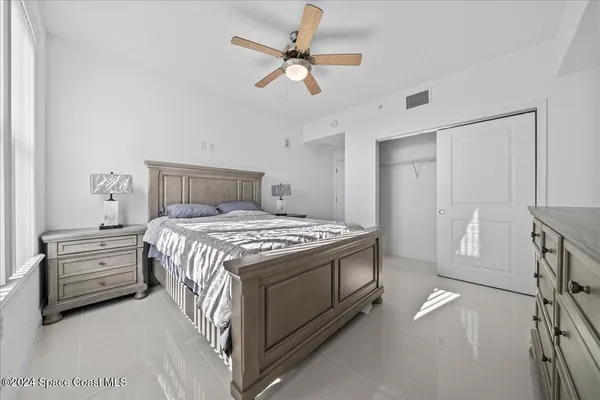 a bedroom with a bed and a ceiling fan
