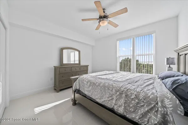 a bedroom with a bed a dresser and next to a window