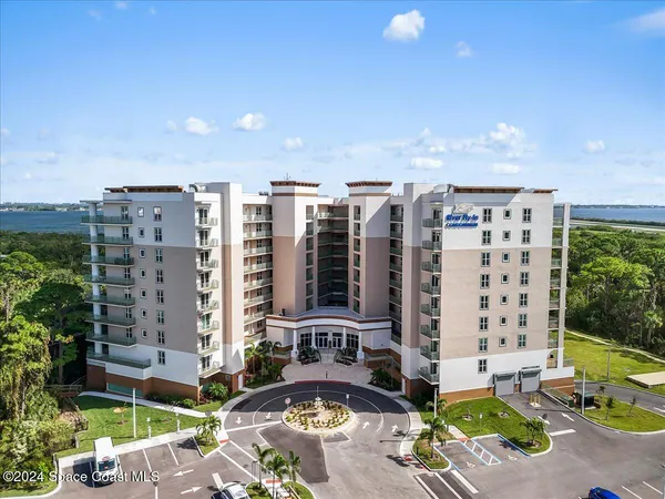 a front view of a building with glass windows and trees